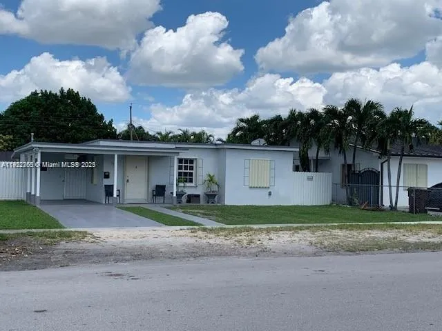 a front view of house with yard and trees in the background