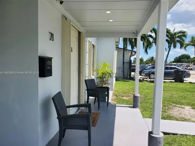 a view of a porch with chairs and potted plants
