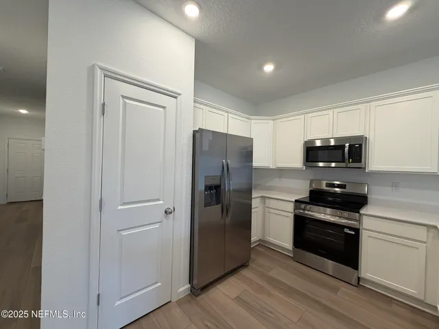 a kitchen with stainless steel appliances granite countertop a refrigerator and a stove top oven