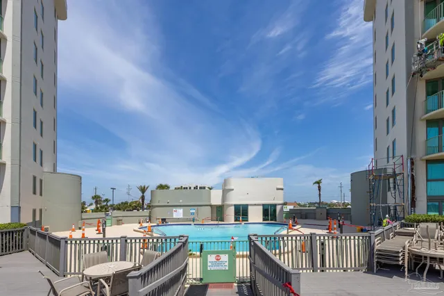 a front view of multi story residential apartment building with yard and outdoor seating