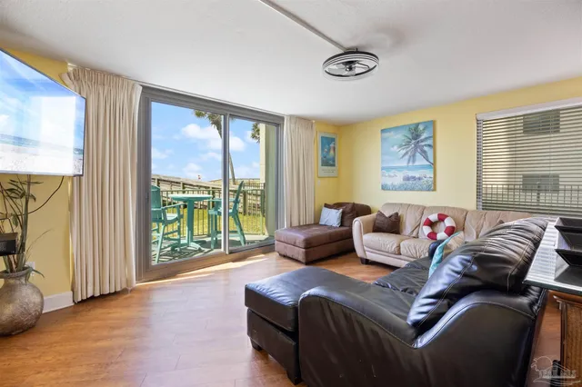 a living room with furniture floor to ceiling window and a flat screen tv