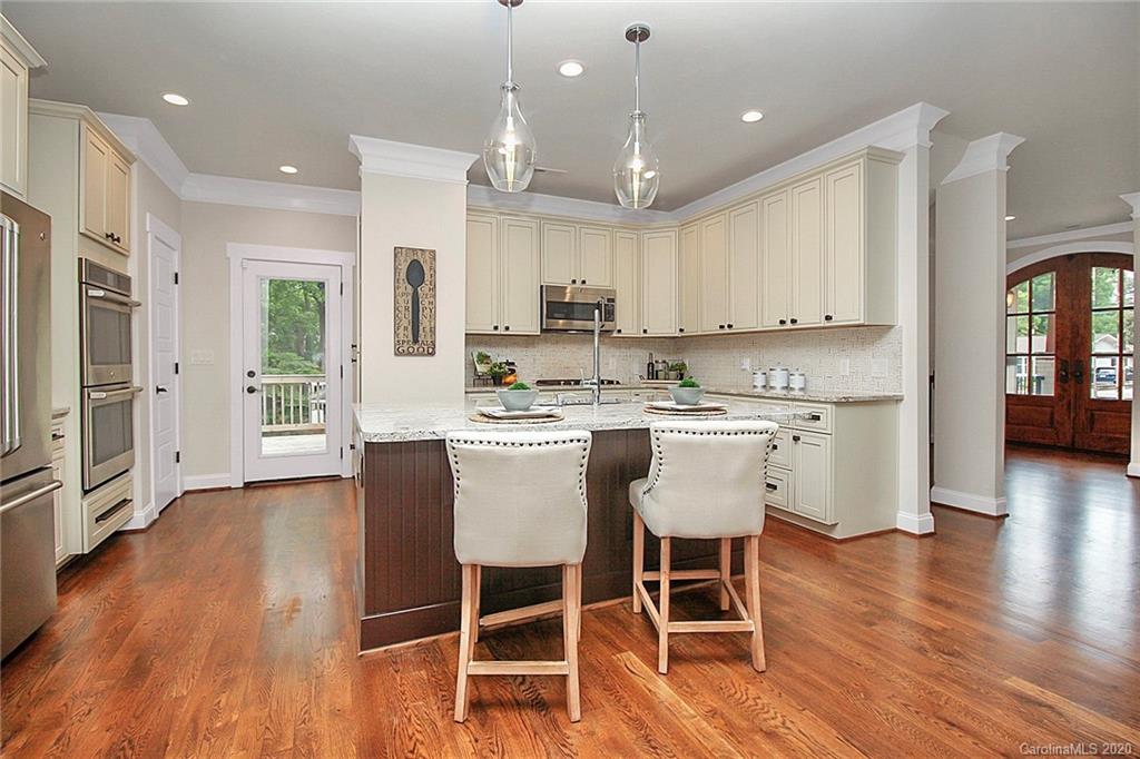 132 Scofield Road Charlotte, NC 28209 - Photo 14 of 44 a kitchen with kitchen island granite countertop a dining table chairs refrigerator and cabinets