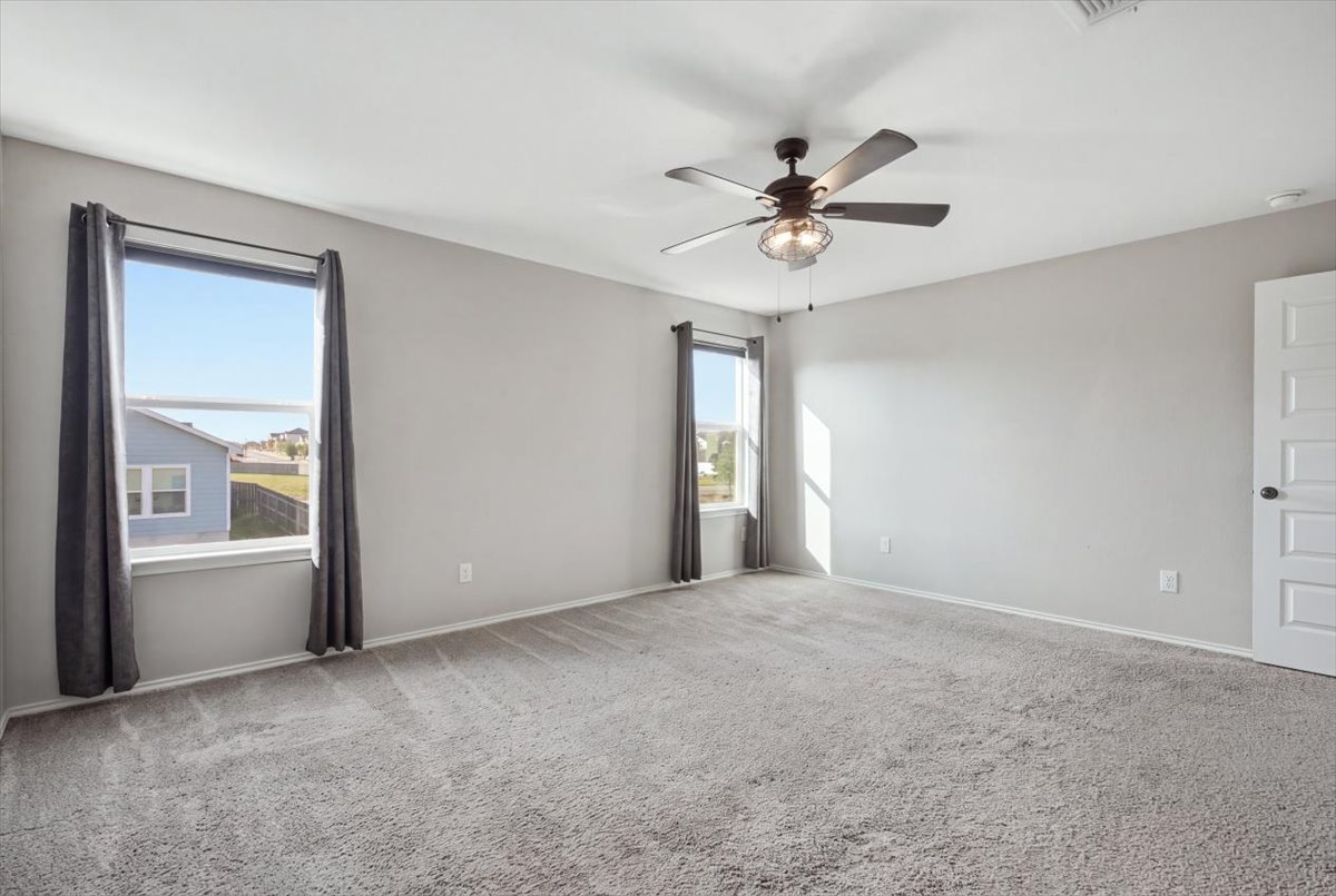 104 Rooster Way Jarrell, TX 76537 - Photo 16 of 33 Generous windows fill this carpeted bedroom with natural light.