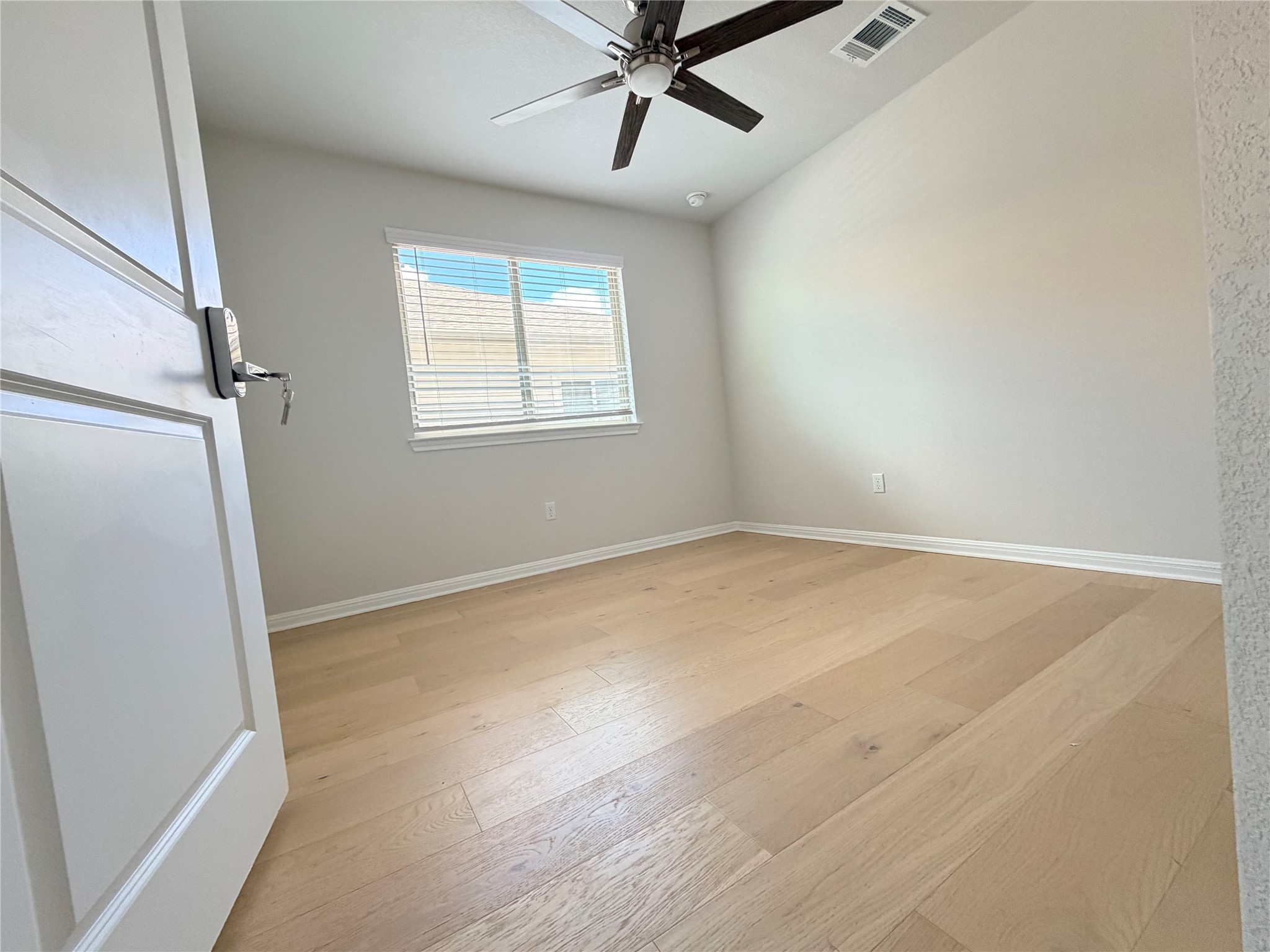 2813 Hopi Path, Unit 11 Leander, TX 78641 - Photo 5 of 17 Empty room with light wood finished floors and a ceiling fan