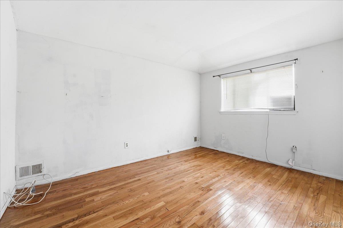 1050 Rensselaer Avenue Staten Island, NY 10309 - Photo 19 of 24 an empty room with wooden floor and windows