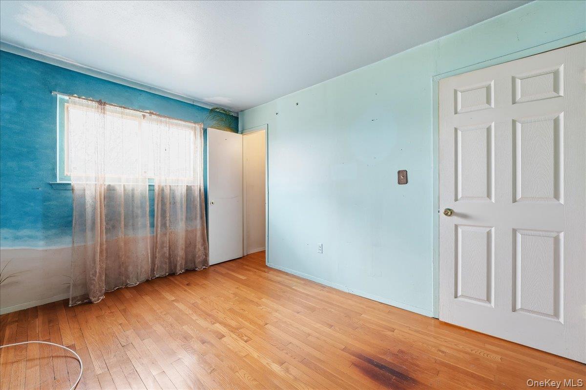 1050 Rensselaer Avenue Staten Island, NY 10309 - Photo 4 of 24 an empty room with wooden floor and windows