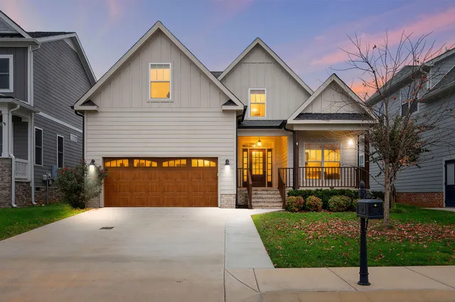 a front view of a house with a yard and potted plants