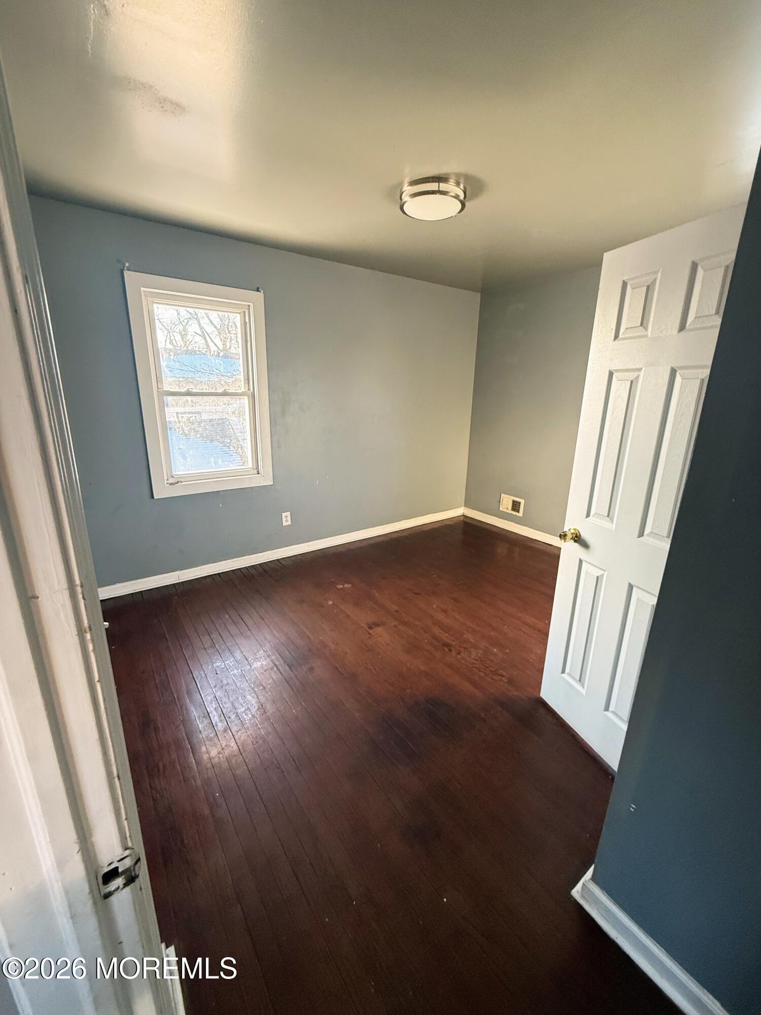 401 Ridge Avenue Asbury Park, NJ 07712 - Photo 8 of 11 a view of an empty room with wooden floor and a window