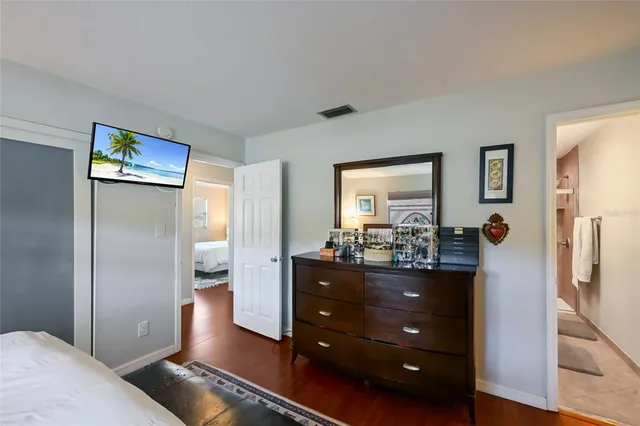 a living room with stainless steel appliances furniture a refrigerator and a dresser