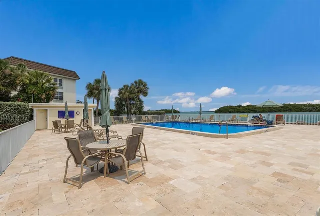 a view of a swimming pool with a lawn chairs and a fire pit