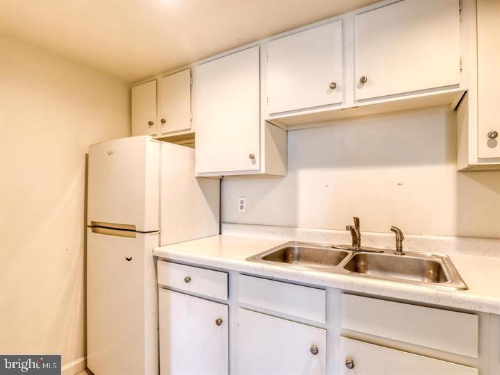103 North Church Street Berryville, VA 22611 - Photo 6 of 13 a white kitchen with sink and white appliances
