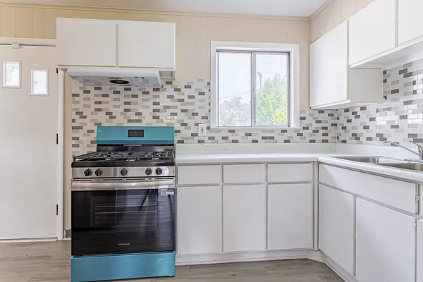 a kitchen with cabinets appliances and a window