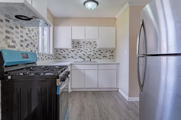 a kitchen with stainless steel appliances a stove a refrigerator and a cabinets
