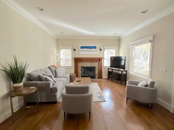 a living room with furniture a fireplace and a flat screen tv