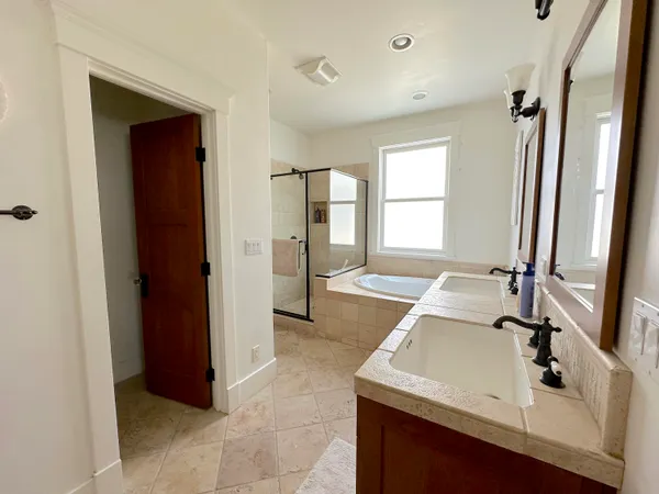 a bathroom with a sink and mirror with bathtub