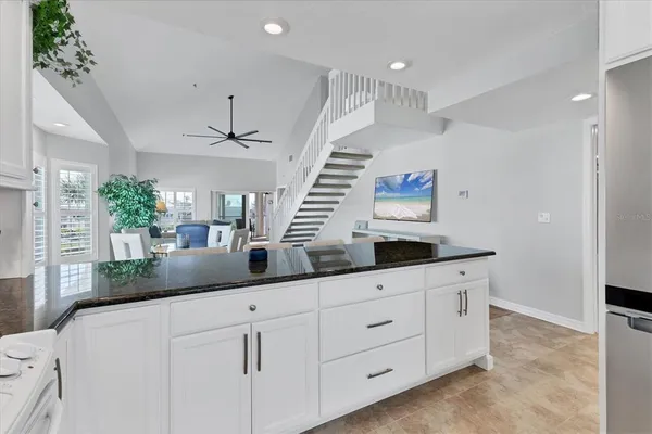 a kitchen with granite countertop a white cabinets and sink