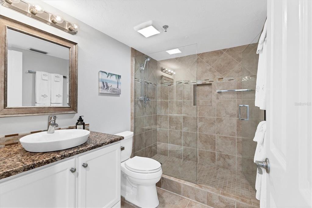 11000 Placida Road, Unit 1603 Placida, FL 33946 - Photo 18 of 44 a bathroom with a granite countertop sink a toilet a mirror and shower