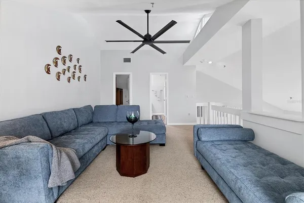 a living room with furniture and a ceiling fan
