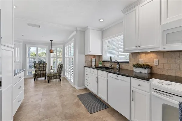 a kitchen with white cabinets and refrigerator