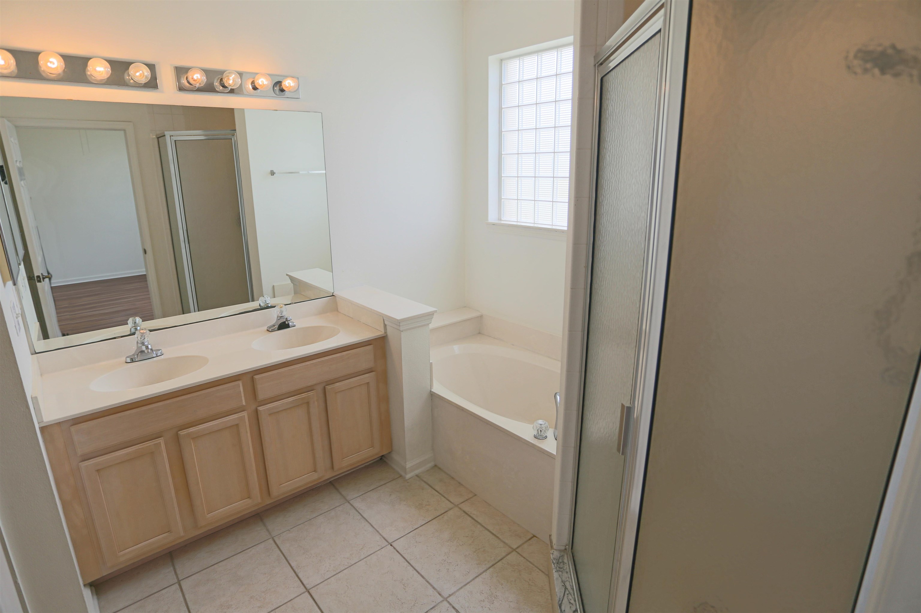 1603 Prestwick Place St. Augustine, FL 32086 - Photo 26 of 44 a bathroom with a double vanity sink a mirror and a bathtub