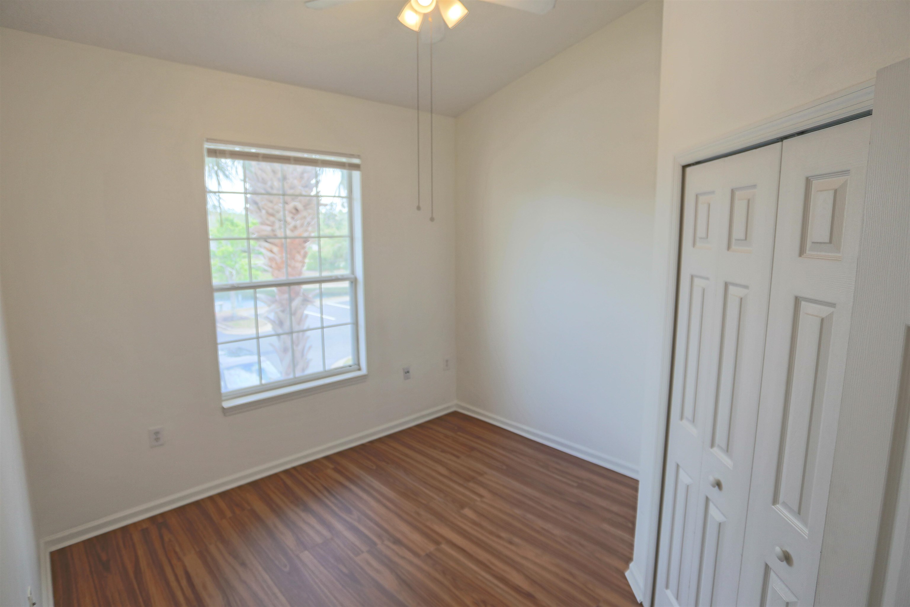 1603 Prestwick Place St. Augustine, FL 32086 - Photo 30 of 44 an empty room with wooden floor chandelier fan and windows
