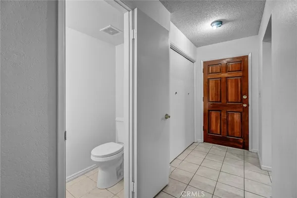 a view of an empty room with wooden floor and stairs
