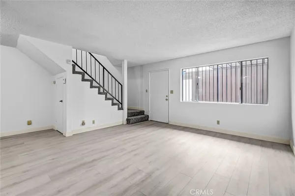 a view of a livingroom with wooden floor and stairs