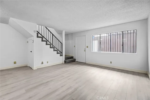 a view of a livingroom with wooden floor and stairs