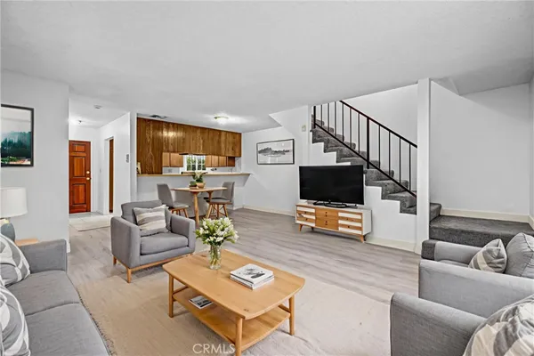 a view of a livingroom with wooden floor and stairs