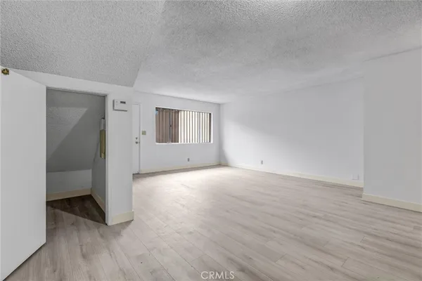 a view of a room that has wooden floor and cabinets