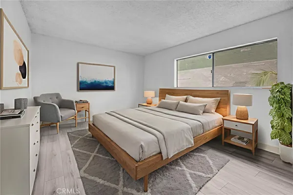 a bedroom with a large bed and a potted plant