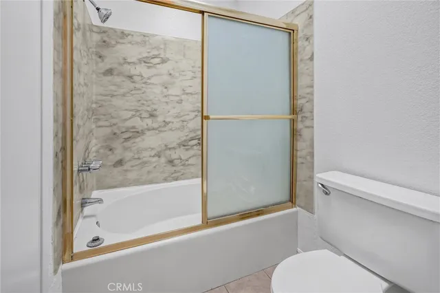 a view of an empty room with wooden floor and closet