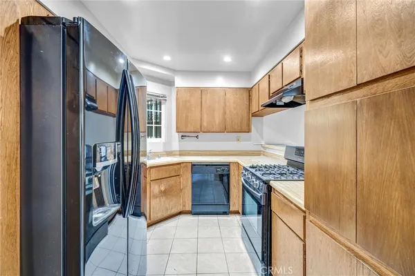 a kitchen with a sink a stove cabinets and a window