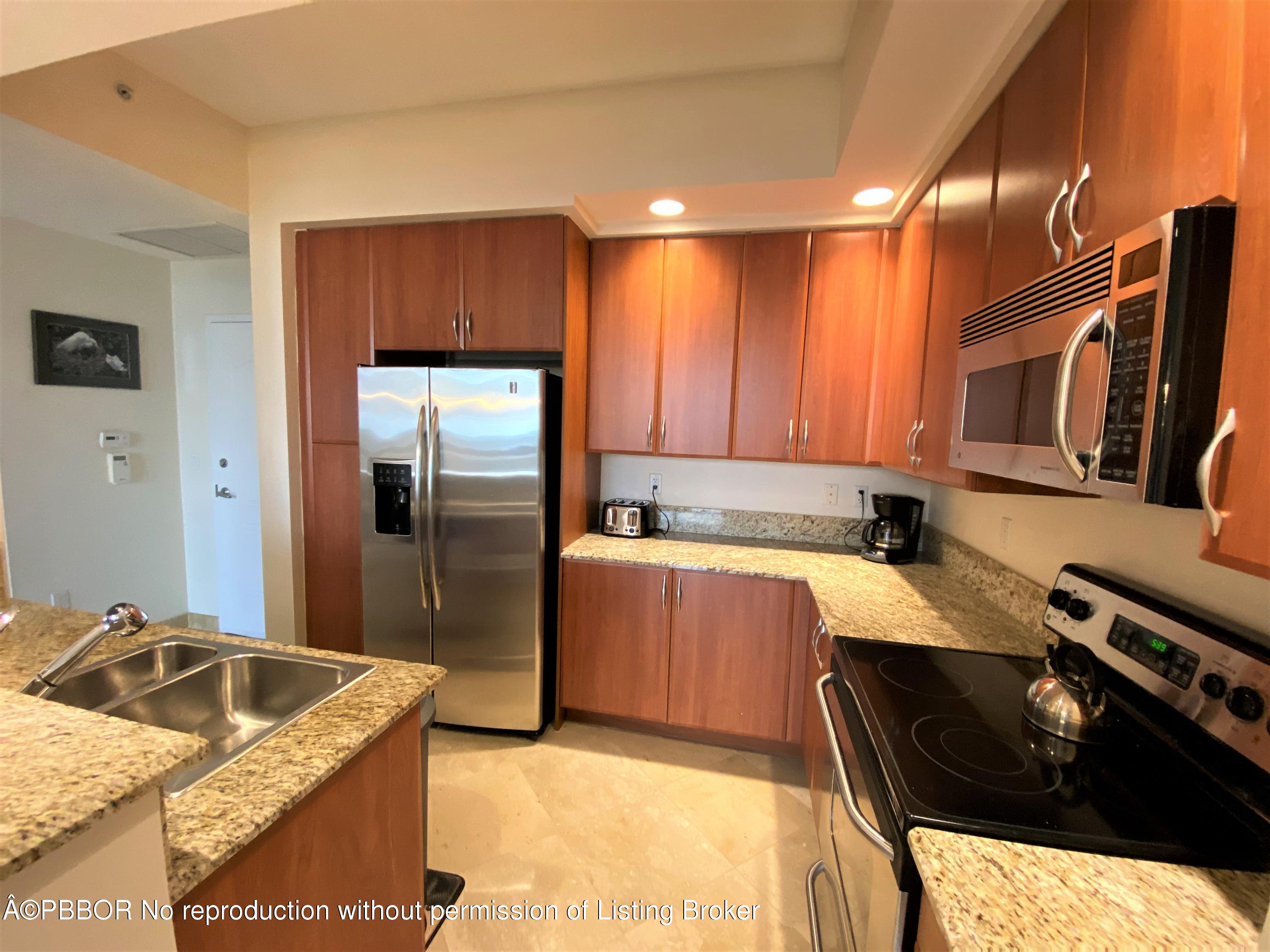 801 South Olive Avenue, Unit 903 West Palm Beach, FL 33401 - Photo 20 of 55 a kitchen with stainless steel appliances granite countertop a sink a stove and a refrigerator