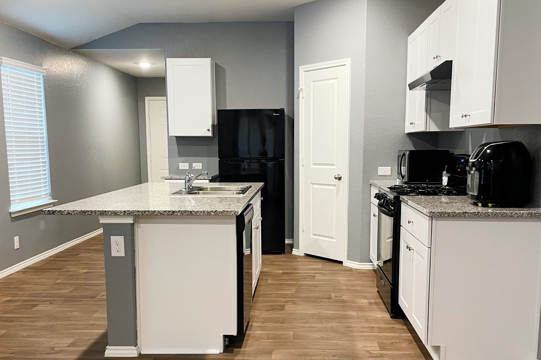 285 Middle Green Loop Floresville, TX 78114 - Photo 2 of 3 a kitchen with stainless steel appliances granite countertop a sink and a refrigerator
