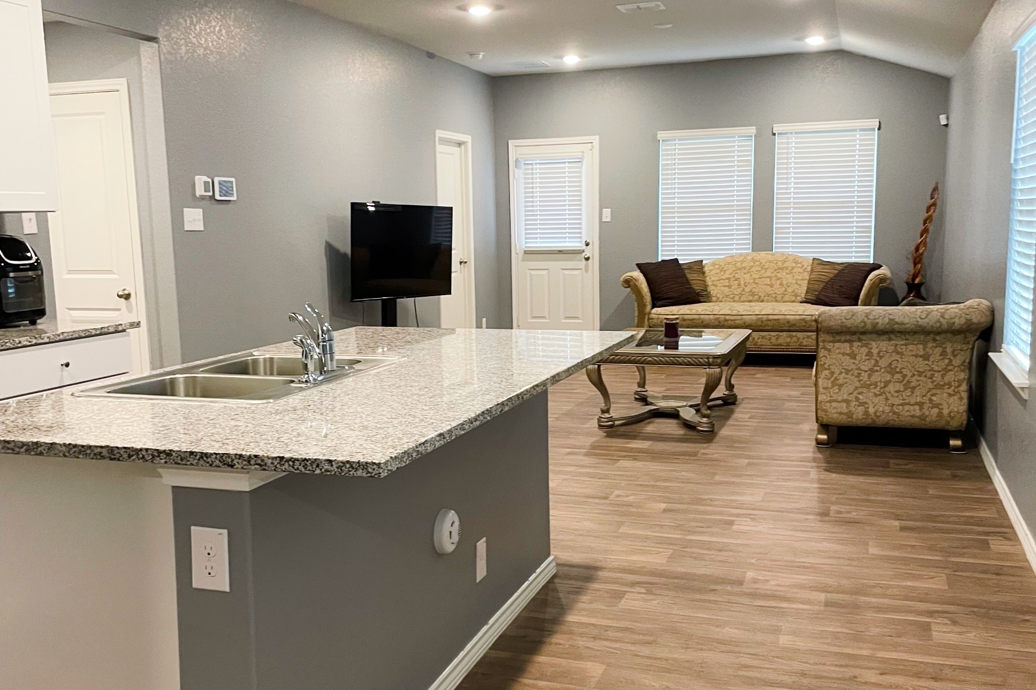 285 Middle Green Loop Floresville, TX 78114 - Photo 3 of 3 a living room with kitchen island furniture and a flat screen tv