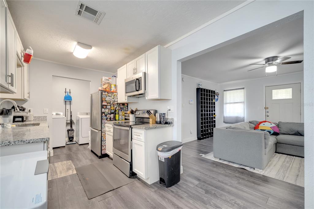 1226 Pine Street Orlando, FL 32824 - Photo 15 of 46 a kitchen with a refrigerator and a stove top oven