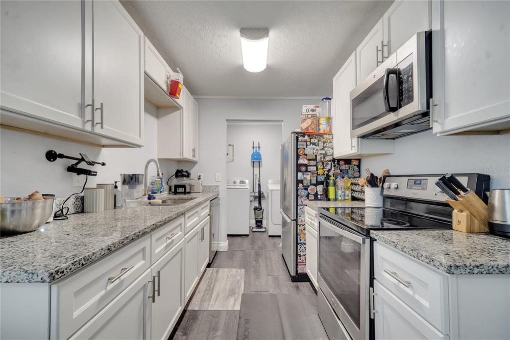 1226 Pine Street Orlando, FL 32824 - Photo 16 of 46 a kitchen with stainless steel appliances granite countertop a sink stove and cabinets