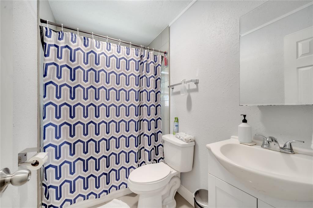1226 Pine Street Orlando, FL 32824 - Photo 24 of 46 a white toilet sitting next to a white sink and a shower curtain