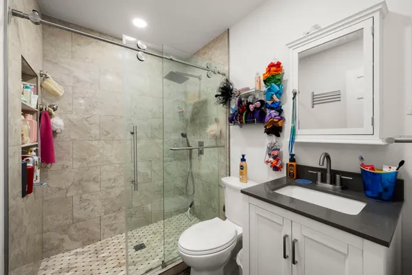 a bathroom with a sink a toilet and shower