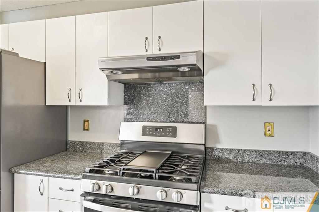 834 Edpas Road New Brunswick, NJ 08901 - Photo 11 of 20 a kitchen with granite countertop a stove and a white cabinets
