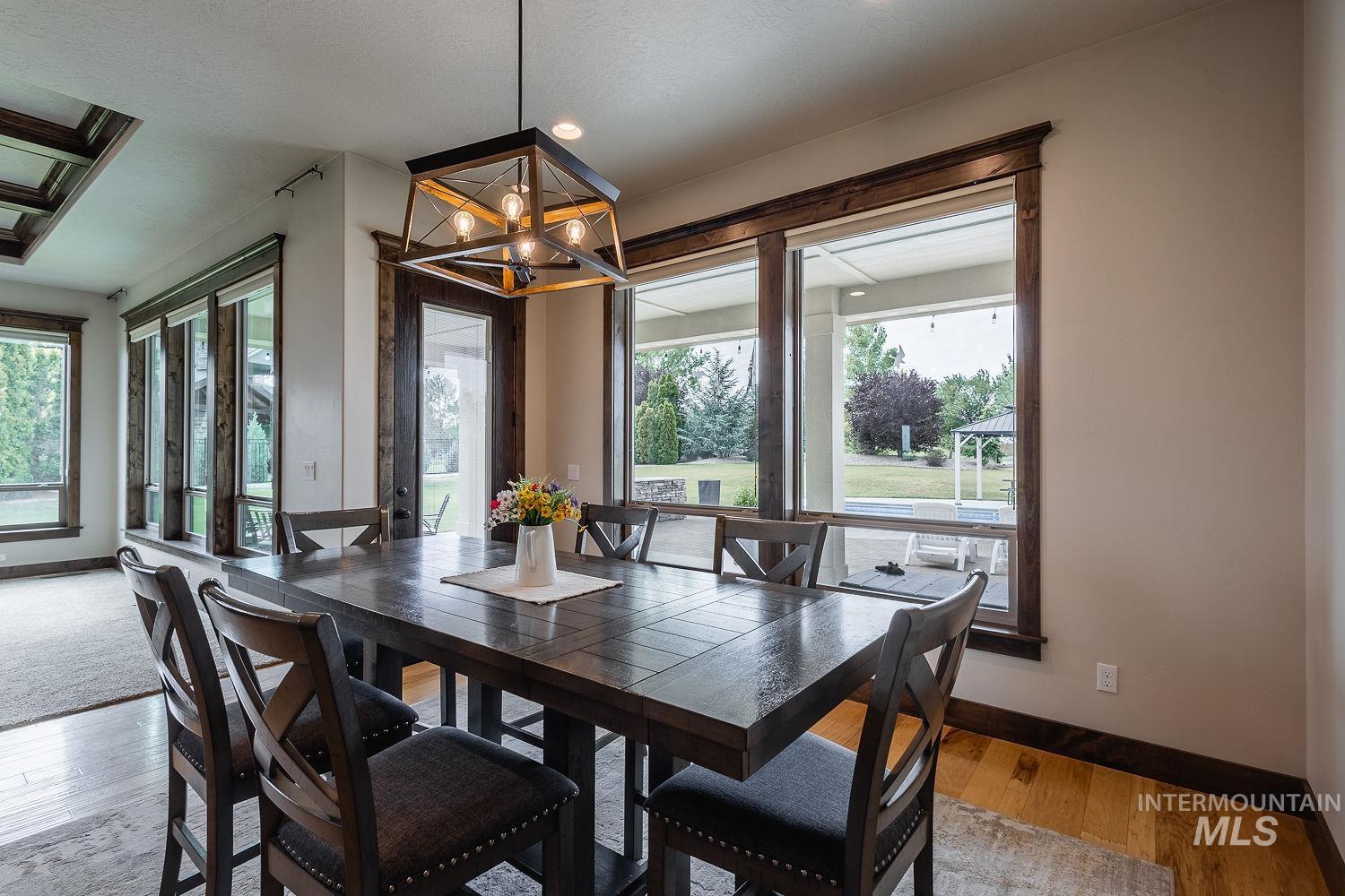 8077 Star Pass Ridge Road Nampa, ID 83686 - Photo 17 of 37 Open-concept dining area featuring a coffered ceiling and wood-finish flooring