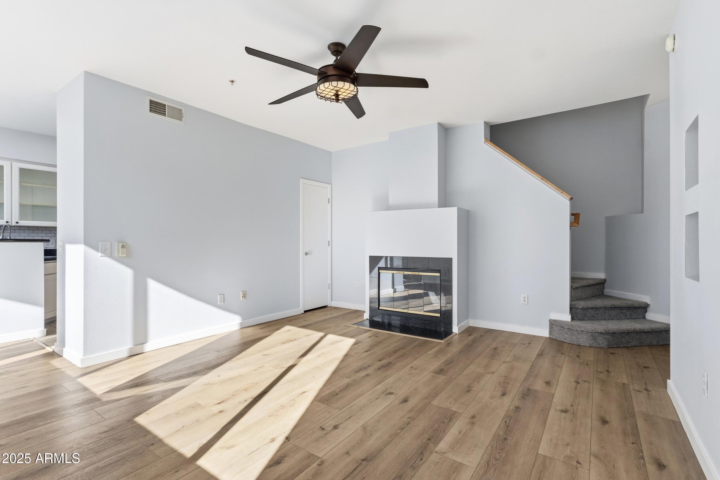 a view of empty room with fireplace and wooden floor