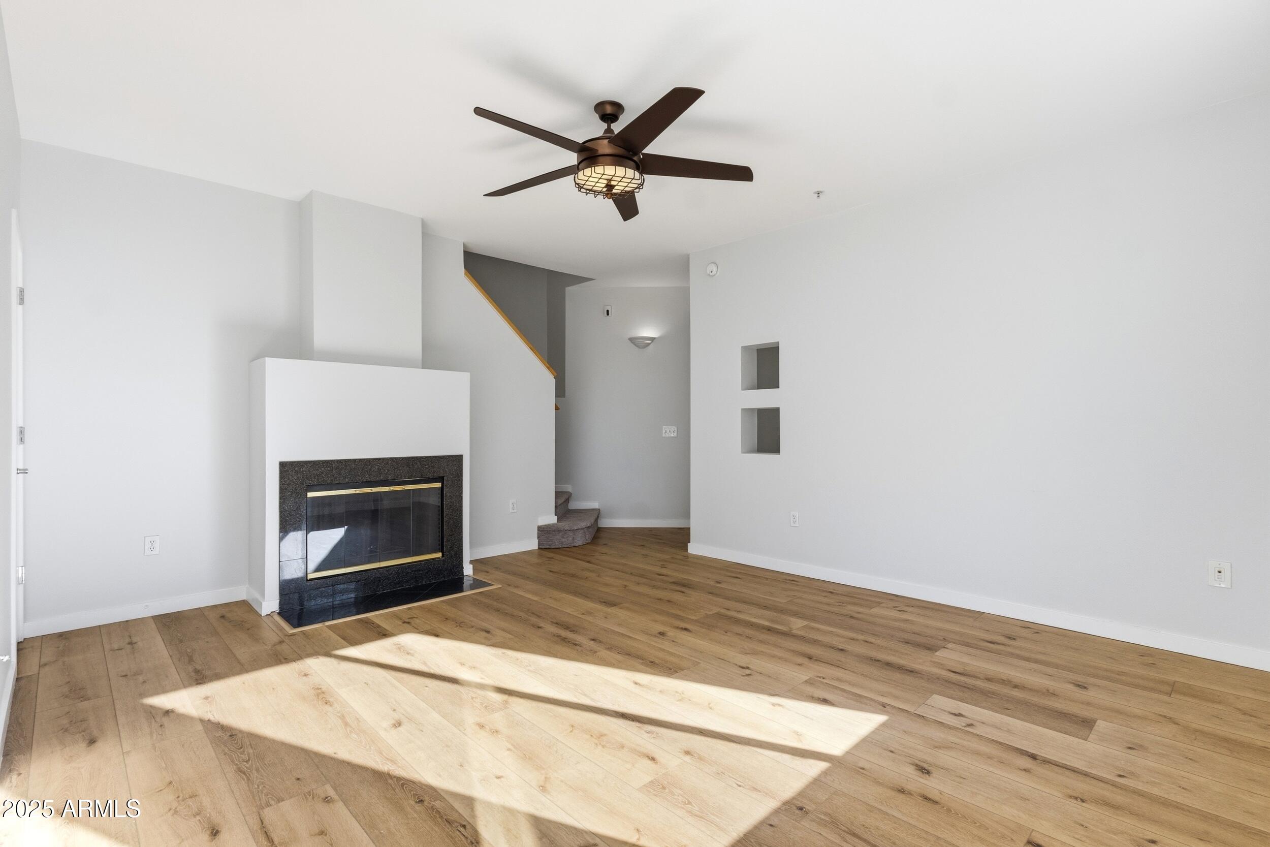 3633 North 3rd Avenue, Unit 2009 Phoenix, AZ 85013 - Photo 11 of 36 a view of empty room with wooden floor and fireplace