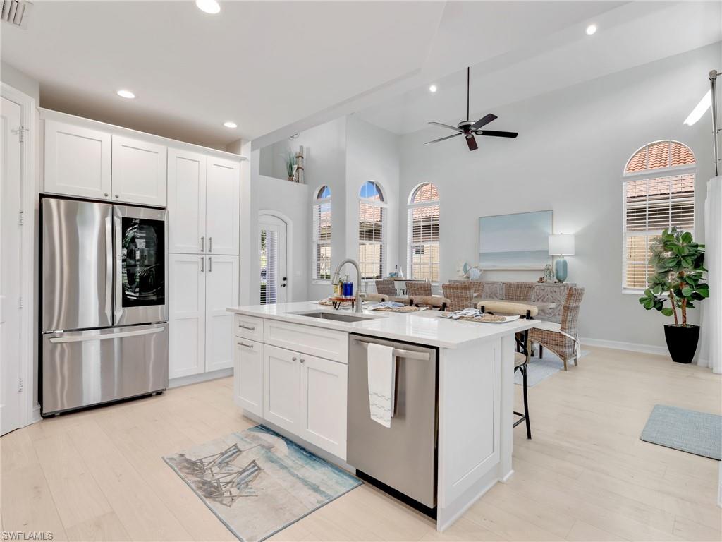 a kitchen with stainless steel appliances kitchen island a stove a sink and a refrigerator