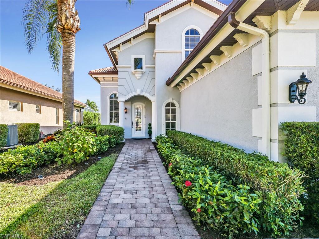 6096 Dogleg Drive Naples, FL 34113 - Photo 12 of 49 a front view of a house with a yard