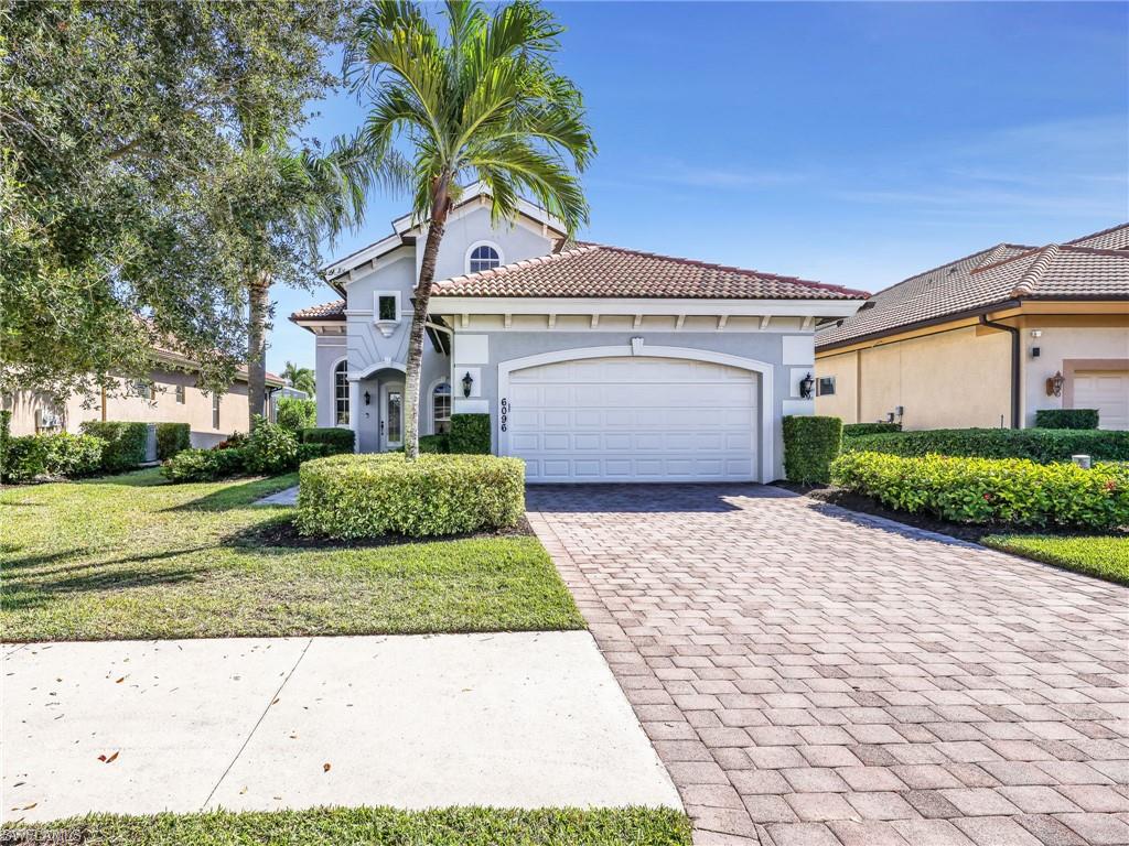 6096 Dogleg Drive Naples, FL 34113 - Photo 13 of 49 a front view of a house with a garden and garage
