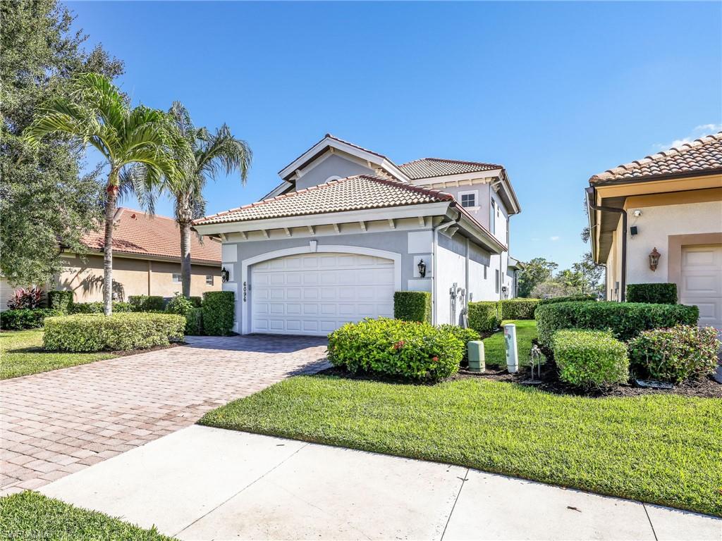 6096 Dogleg Drive Naples, FL 34113 - Photo 14 of 49 a front view of a house with a yard and garage