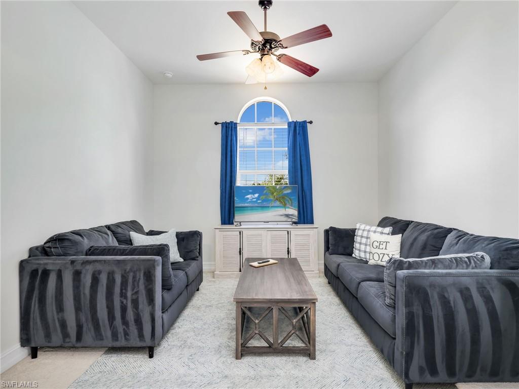6096 Dogleg Drive Naples, FL 34113 - Photo 29 of 49 a living room with furniture a couch and a chandelier