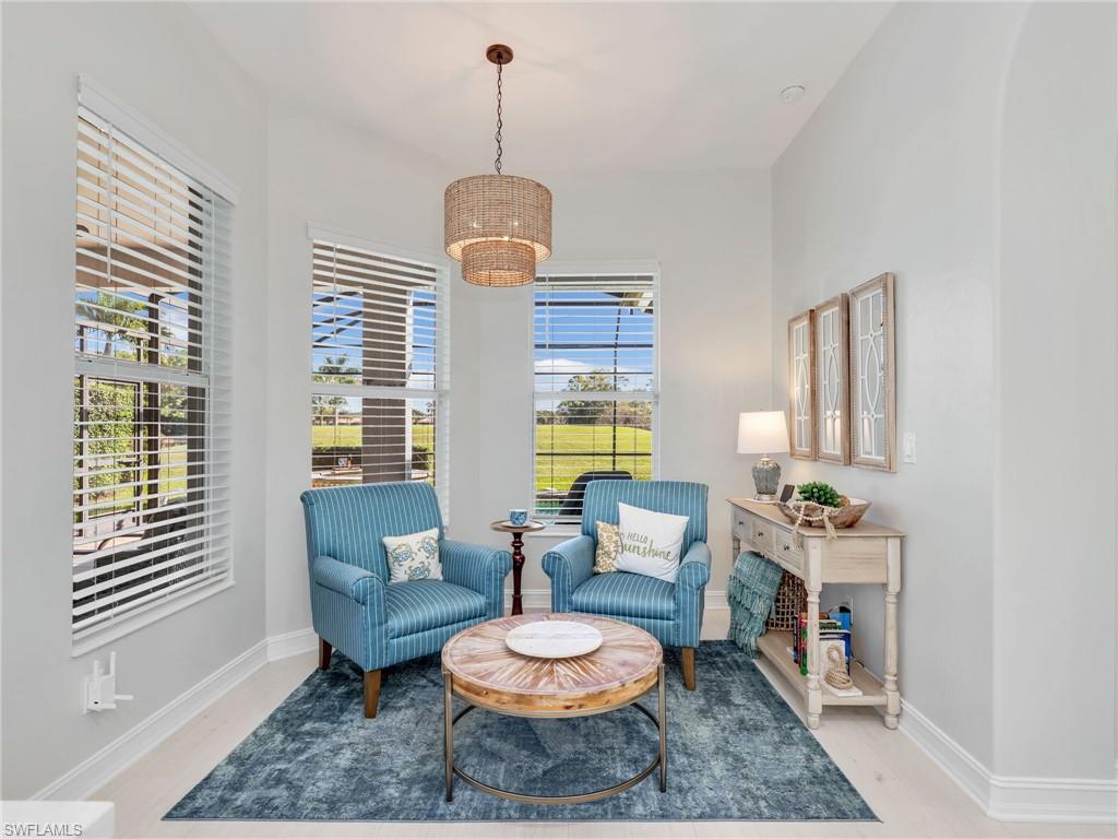 6096 Dogleg Drive Naples, FL 34113 - Photo 30 of 49 a living room with furniture and a chandelier